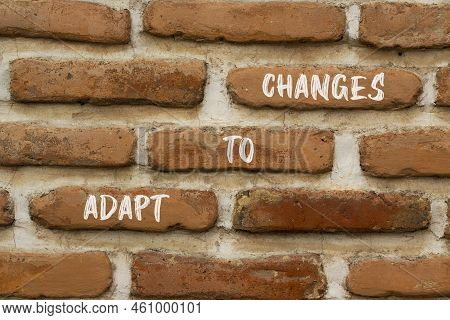Adapt To Changes And Support Symbol. Concept Words Adapt To Changes On Red Brick Wall. Beautiful Red