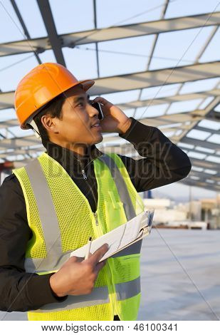 Costruzione ingegnere parlando cellulare sotto nuova costruzione
