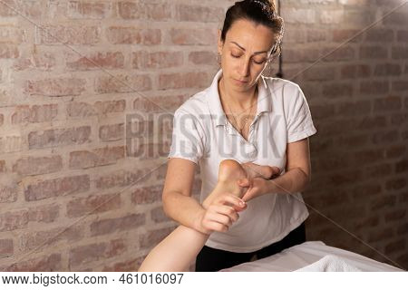 Doctor Masseur Making Manual Massage Of Feet For Lying Woman In Wellness Clinic. Osteopath Massages 