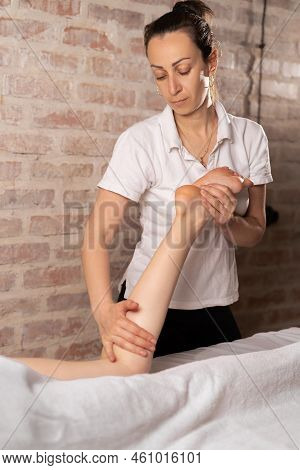 Doctor Masseur Making Manual Massage Of Feet For Lying Woman In Wellness Clinic. Professional Chirop