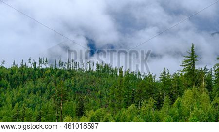 Clouds In The Tatra Mountains Before The Storm. Evergreen Spruce Forests At The Foot Of The Mountain