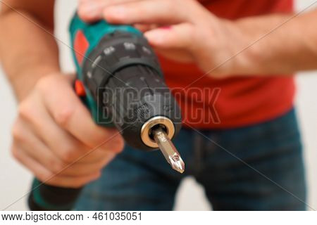Hand Holding Cordless Drill. Handyman With A Tool Screwdriwer Drill. Electrician With Drill. Worker 