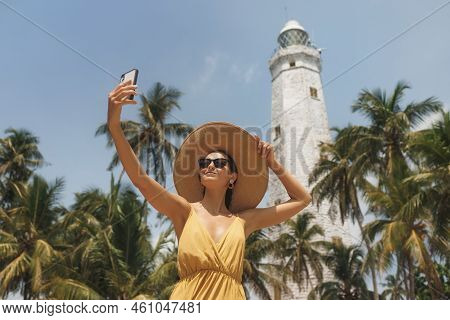Romantic Woman Traveler In Dress And Straw Hat Taking Selfie On Smartphone Of Famous Landmarks Of Sr