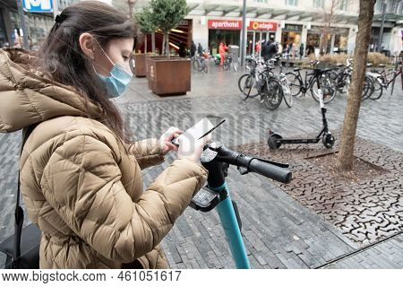 Brussels Belgium - 01.31.2022 A Young Woman In A Warm Down Jacket And A Mask