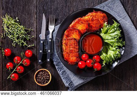 Grilled Slices Of Pork Loin Marinated In Paprika Based Sauce On Black Plate With Fresh Tomatoes And 