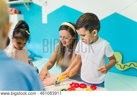 Calming Sensory Play With Moldable Kinetic Sand At Nursery School. Toddlers With Their Teacher Havin
