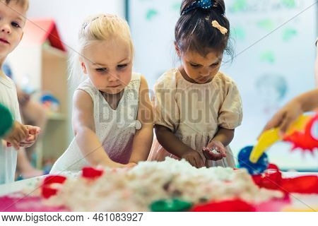 Relaxing Sensory Play With Moldable Kinetic Sand At Nursery School. Toddlers Having Fun Around The T