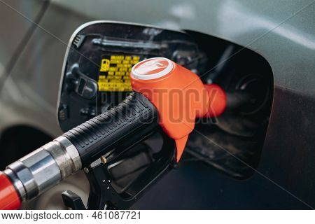 Fuel Nozzle Filling Petrol Into Car Tank At Gas Station. Image With Selective Focus