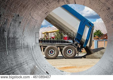 A Large Dump Truck Unloads Rubble Or Gravel At A Construction Site. Car Tonar For Transportation Of 