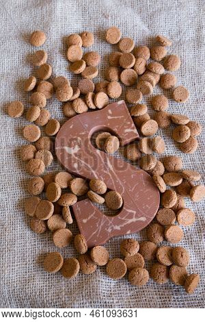 Dutch Sinterklaas Tradition: A Chocolate Letter And Candy Called Pepernoten On A Jute Background.
