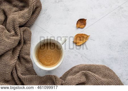 Cup Of Coffee Cappuccino, Beige Sweater And Dry Autumn Leaves On Table Background. Cozy Beige Autumn