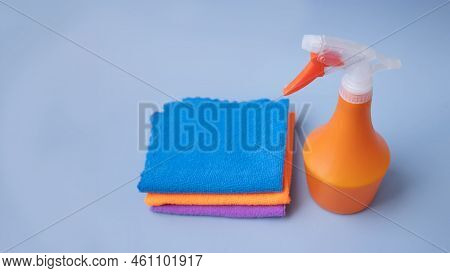 On A Blue Background, An Orange Pulevizer Next To Microfiber Cleaning Cloths Top View