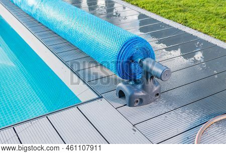 Manual Outdoor Swimming Pool Solar Blanket Cover Roller Or Reel Close Up. Maintenance Water Temperat