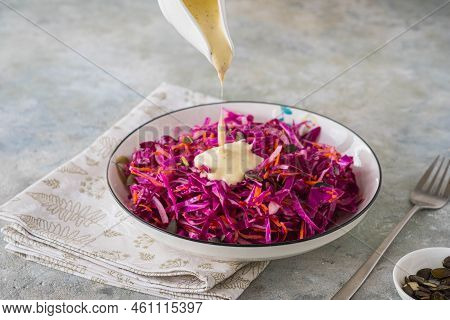 Coleslaw Salad Of Red Cabbage And Carrots With Mayonnaise Dressing In A White Bowl On A Gray Concret