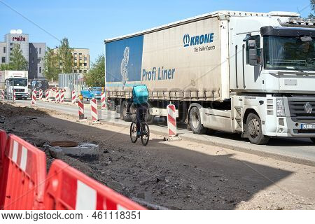 Riga, Latvia - May 13, 2022. A Cyclist From Wolt Food Delivery Company Rides Against Traffic By The 