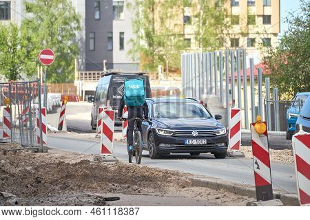 Riga, Latvia - May 13, 2022. A Cyclist From Wolt Food Delivery Company Rides Against Traffic By The 