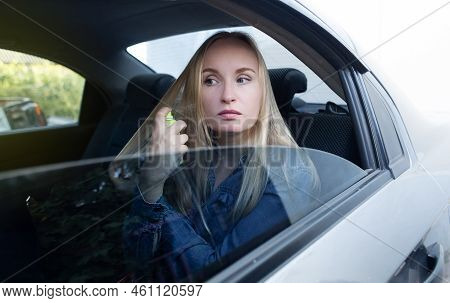 Dry Shampoo. Blonde Girl Sprays Shampoo On Her Hair. The Problem Of Oily Hair While Traveling. An Em