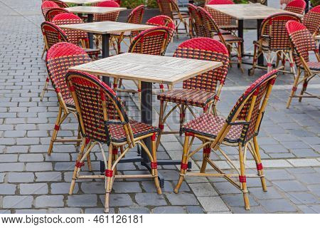 Wooden Tables With Rattan Chairs At Cobbled Street
