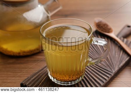 Cup Of Aromatic Buckwheat Tea And Granules On Wooden Table