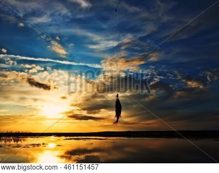 Fishing At Sunset. Catching Predatory Fish On Spinning. Sunset Colors On The Water Surface, Sunny Pa