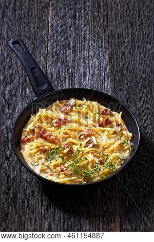 Capunti Pasta In Cream Pecorino Cheese And Pancetta Sauce On Pan On Dark Wooden Table, Vertical View