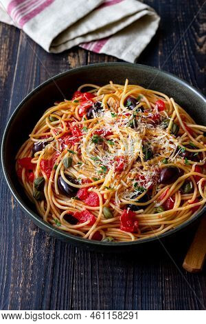 Spaghetti Pasta Alla Puttanesca With Capers, Kalamata Olives, Cheese, Tomatoes And Anchovies. Italia
