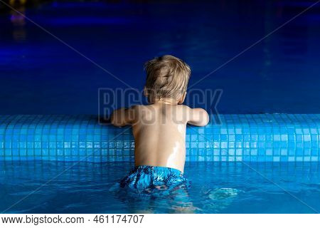 Back View Of Little Cute Adorable Blond Caucasian Alone Kid Boy Enjoy Have Fun Play Relax At Edge Cl