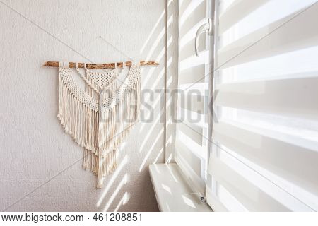 Handmade Macrame Wallhanging. 100% Cotton Wall Decoration With Wooden Stick Hanging On A White Wall.