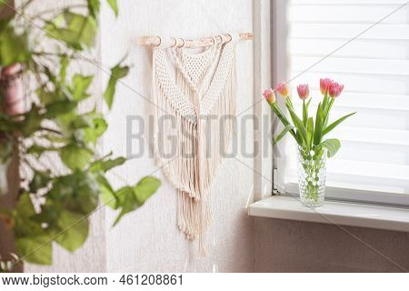 Handmade Macrame Wallhanging. 100% Cotton Wall Decoration With Wooden Stick Hanging On A White Wall.