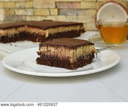 Coconut Cake On White Plate With A Spoon And Caramel Sauce