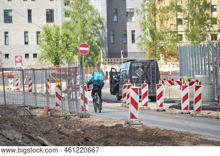 Riga, Latvia - May 13, 2022. A Cyclist From Wolt Food Delivery Company Rides Against Traffic By The 