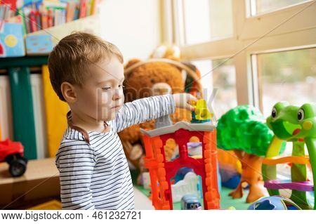 Toddler Boy Plays With Toys In The Children's Room. Educational Toys For Young Children. Child One A
