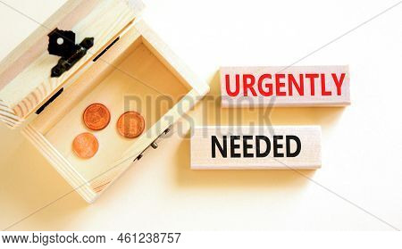 Urgently Needed Symbol. Concept Words Urgently Needed On Wooden Blocks On A Beautiful White Table Wh
