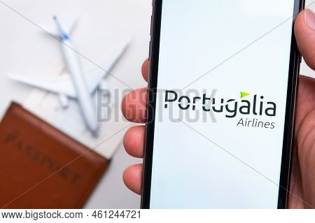 Portugalia Airlines Company App Or Logo Displayed On A Mobile Phone With Passport, Boarding Pass, An