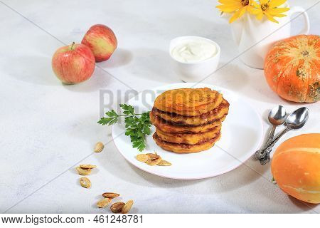 Delicious Russian Pancakes With Pumpkin And Apples, Served With Sour Cream. Traditional Autumn Break