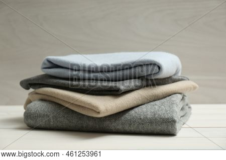 Stack Of Cashmere Clothes On Wooden Table