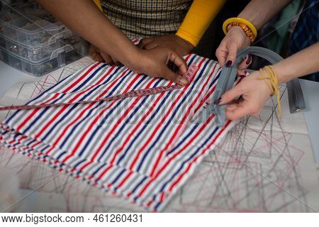 Clothing Designers Measure Tailors Fabric On A Tailors Table.