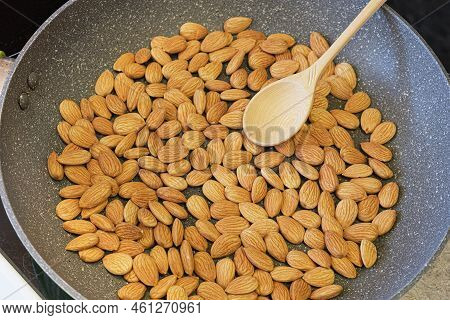 Roasting Almond Kernels In A Frying Pan. Peeled Almonds Are Fried In A Pan And Stirred With A Wooden