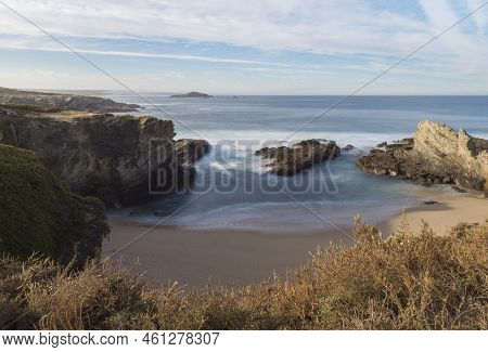 View Of Empty Praia Dos Buizinhos Sand Beach With Long Exposure Blurred Ocean Waves And Sharp Rock A