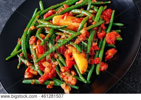 Fasolakia Lathera, Green Beans, Onion And Potatoes Stewed In Tomato, Herbs And Olive Oil On Black Pl