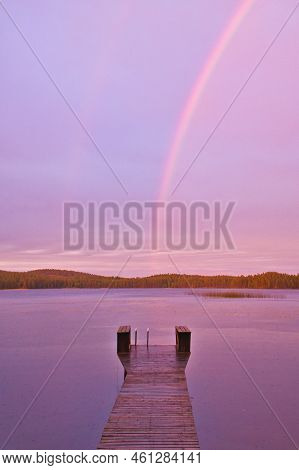 Footbridge Reaching Into The Water At Sunset With Rainbow In The Background When It Rains. Nature Ph