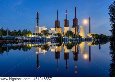 A Power Station In Berlin At Night With A Perfect Reflection In The Water