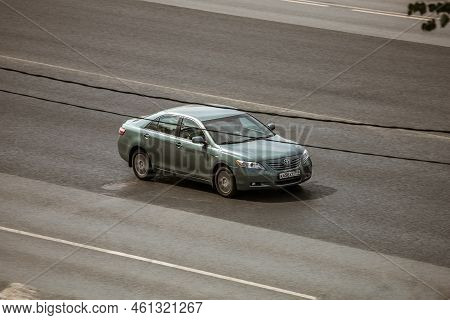 Green Toyota Camry Cruising The Highway. Aerial View Of Shiny Car Moving On The City Road. Moscow, R