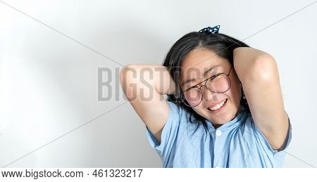 A Young Asian Girl Touch Her Hair Smoothly With A Big Smile On Her Face. She Is Wearing A Light Blue