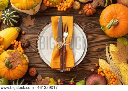 Thanksgiving Day Concept. Top View Photo Of Plate Knife Fork Napkin Raw Vegetables Pumpkins Apples M