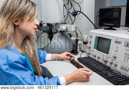 Young Female Scientist Loading A Grid With An Specimen On The Sample Holder Of A Transmission Electr