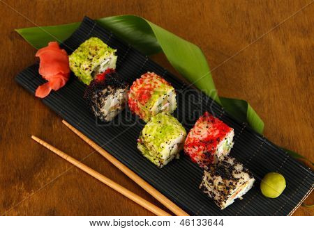 Velsmagende Maki sushi - Roll på måtten på brune baggrund