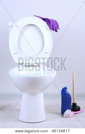 Hvid toiletkummen og renere flaske i badeværelse