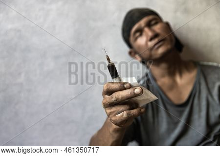 The Concept Of Anti Drugs. A Man Is A Drug Addict With A Syringe Using Drugs Lying On The Floor.  Ma