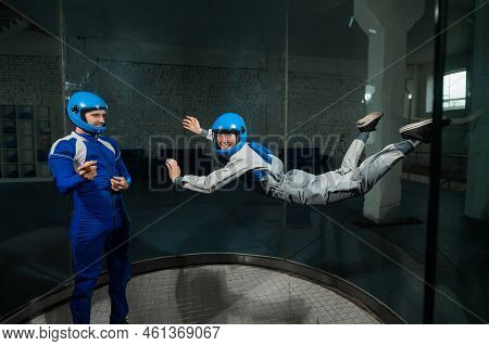 A Man Teaches A Woman How To Fly In A Wind Tunnel. Free Fall Simulator.